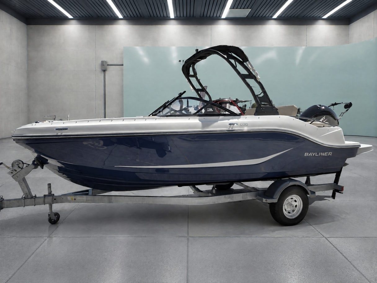 The same Bayliner on its trailer in a concrete bay with a mint green wall.