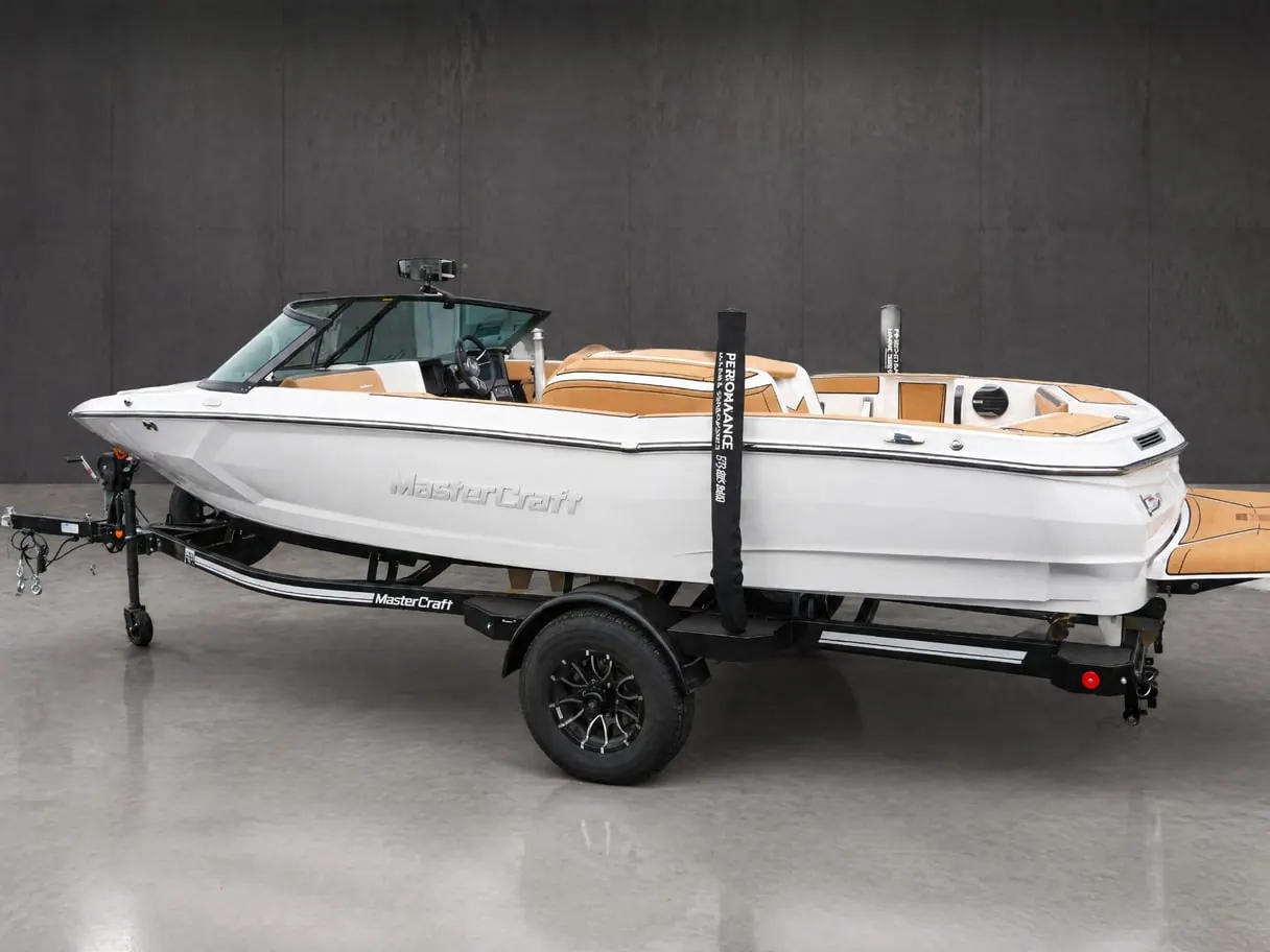 The same MasterCraft on its trailer on a polished concrete floor in front of a dark concrete wall.